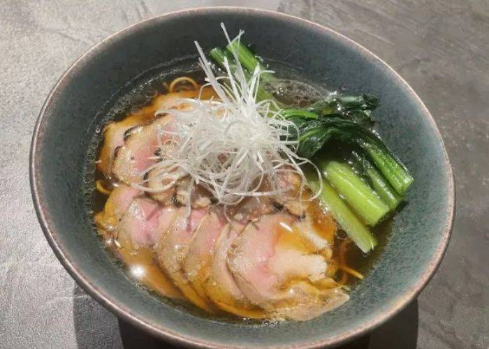 A fresh serving of ramen at Noodle Shop Rennosuke, featuring generous portions of sliced pork.